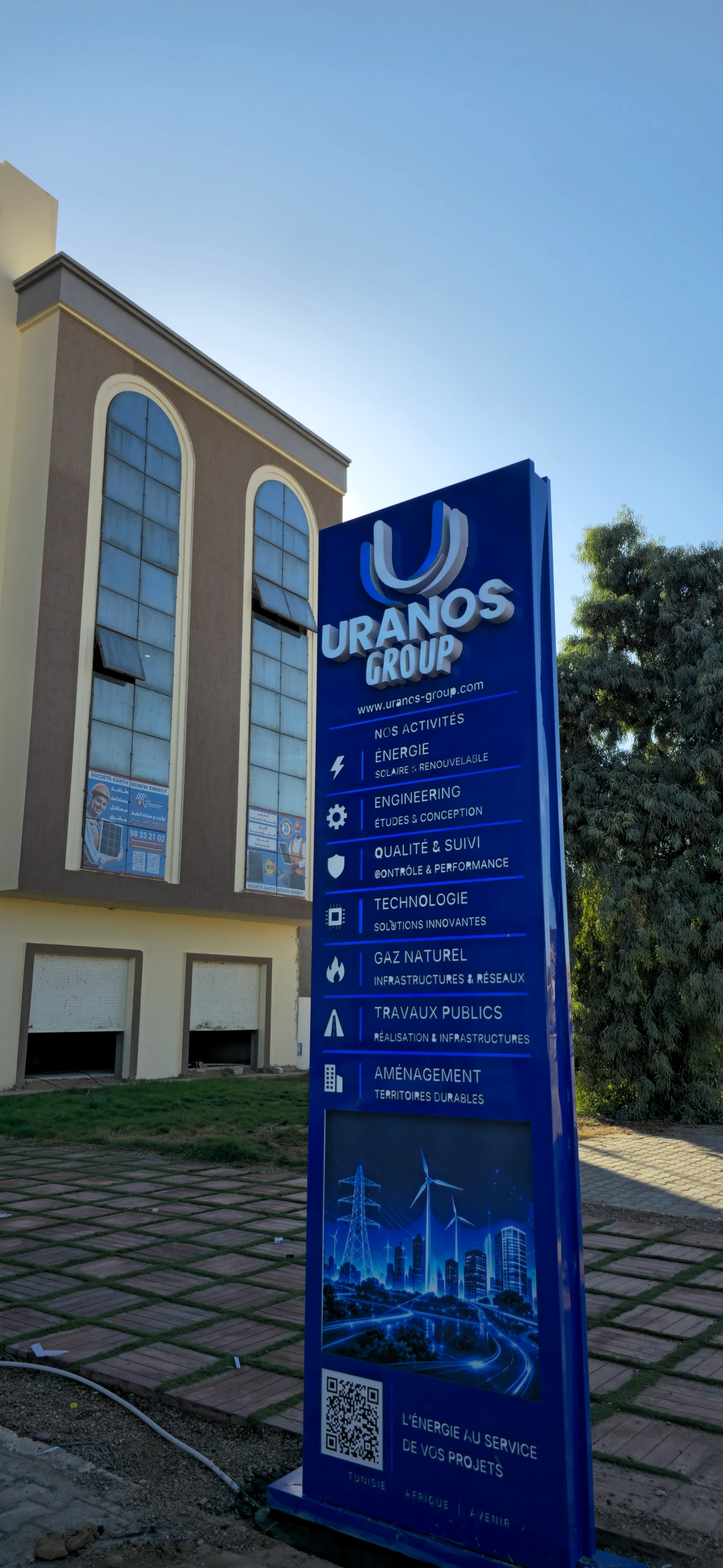 Totem URANOS GROUP de jour entièrement visible, du logo jusqu’au socle, à Médenine